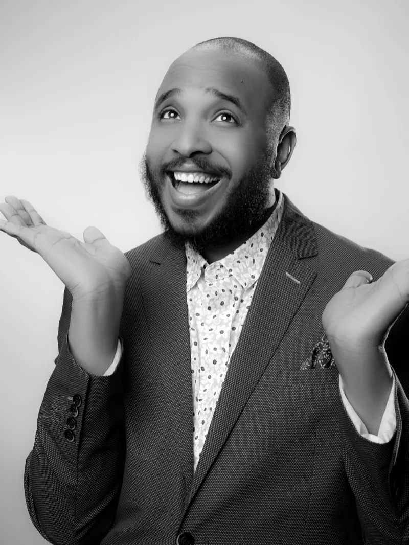 Bearded man in a suit laughing with both palms raised